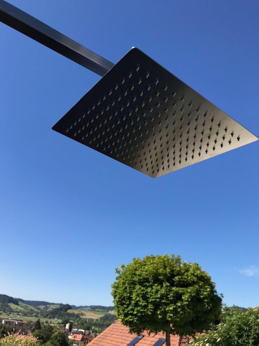 Regenwald-Duschkopf aus Edelstahl vor blauem Himmel