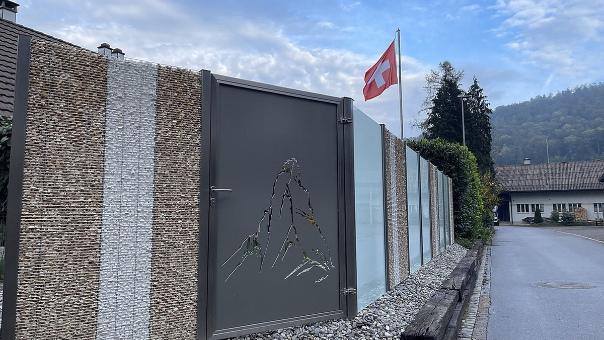 Sichtschutz mit Edelstahl-Steinkörben, Milchglas und Gartentüre mit gelasertem Matterhorn-Sujet