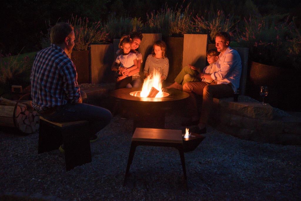 Familie am ASGARD Feuerherd in der Abendstimmung