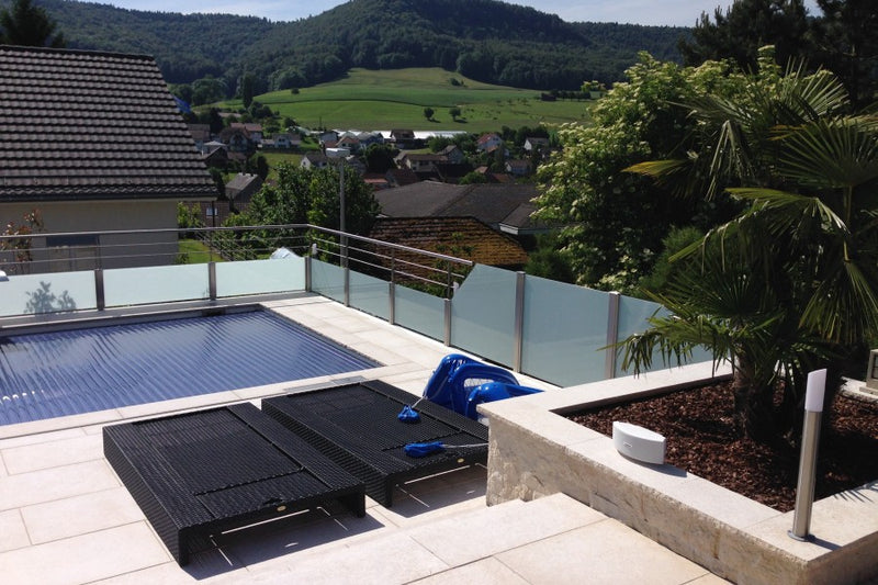Absturzsicherung rund um den Pool: VSG-Milchglas und horizontale Vollstäbe, oben mit Handlauf