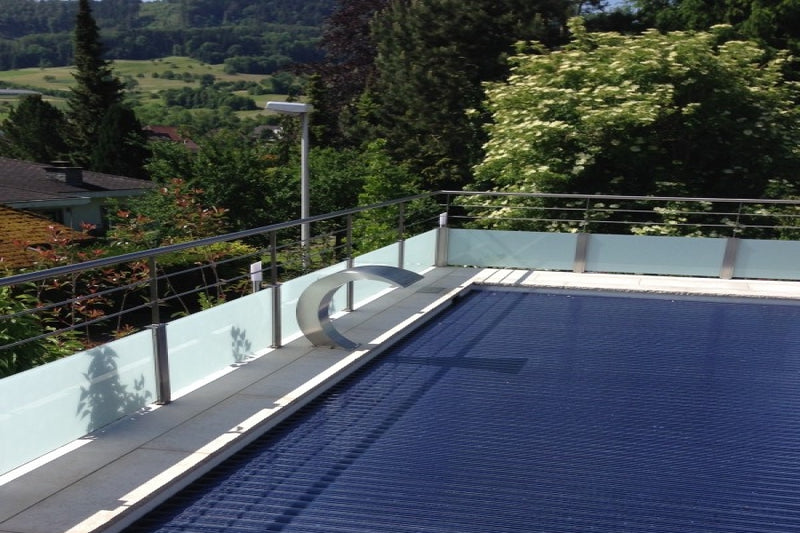 Absturzsicherung rund um den Pool: VSG-Milchglas und horizontale Vollstäbe, oben mit Handlauf