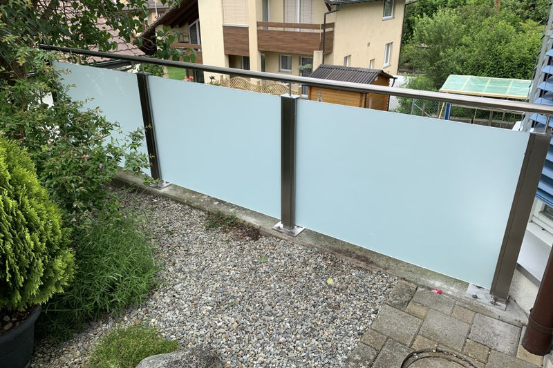 Glas-Absturzsicherung mit Handlauf, montiert auf eine bestehende Betonmauer