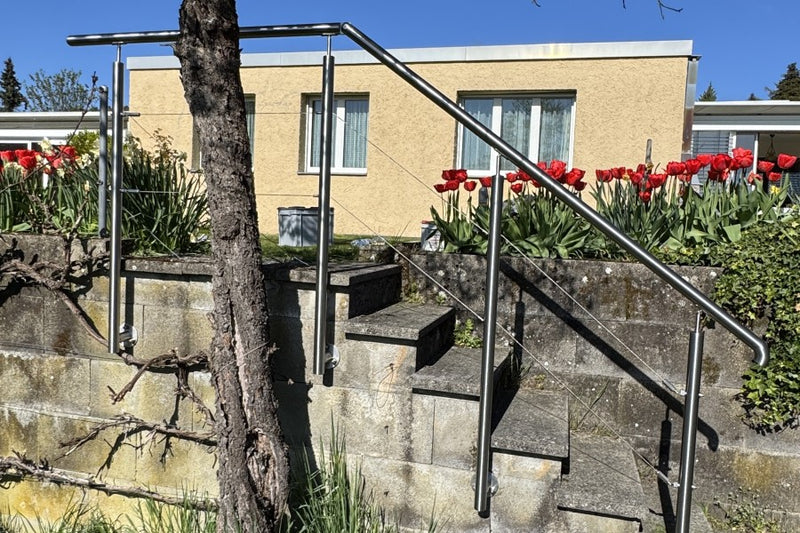 Treppengeländer mit Handlauf und Spannseilen, befestigt am bestehenden Mauerwerk