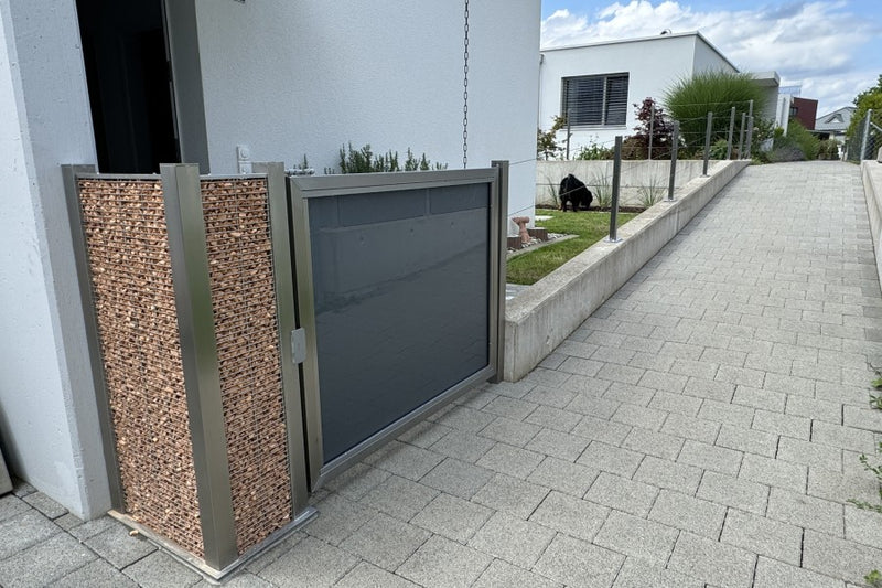 Spannseilgeländer auf Betonwand mit Gartentüre als Abschluss