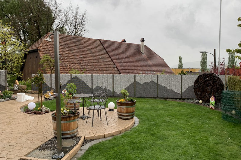 Steinkorb-Sichtschutz mit Wellenmuster-Füllung und Kaltwasser-Gartendusche – Trimstein BE