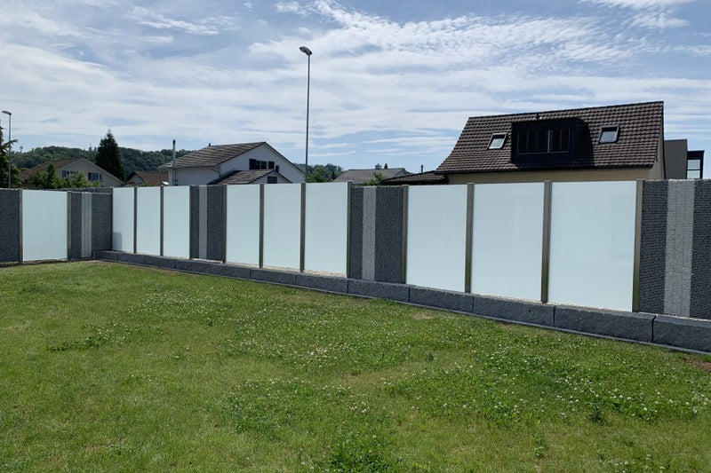 Sicht-, Wind- und Schallschutz aus Steinkörben und VSG-Milchglas – Kaisten AG