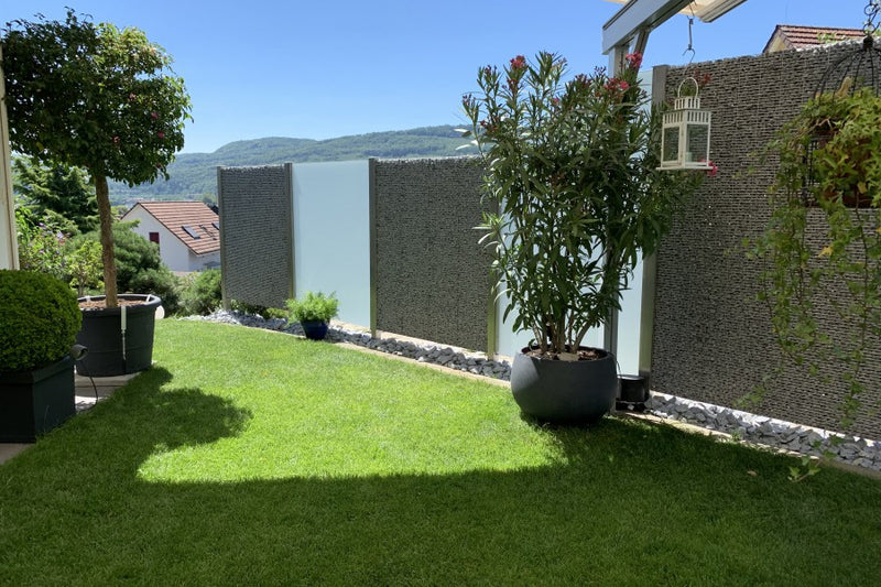 Sicht- und Windschutz aus Steinkörben und VSG-Milchglas – Wallbach AG