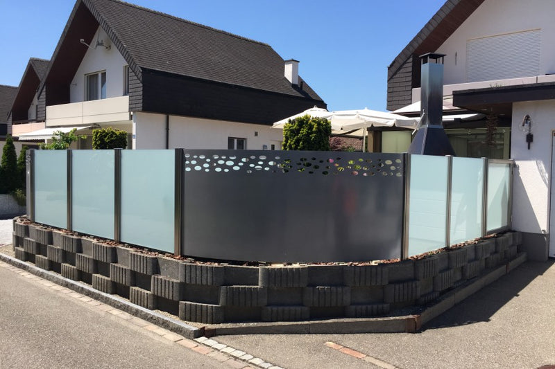 Sicht- und Windschutz aus VSG-Milchglas und gerundetem Aluminiumblech mit gelasertem Sujet – Möhlin AG