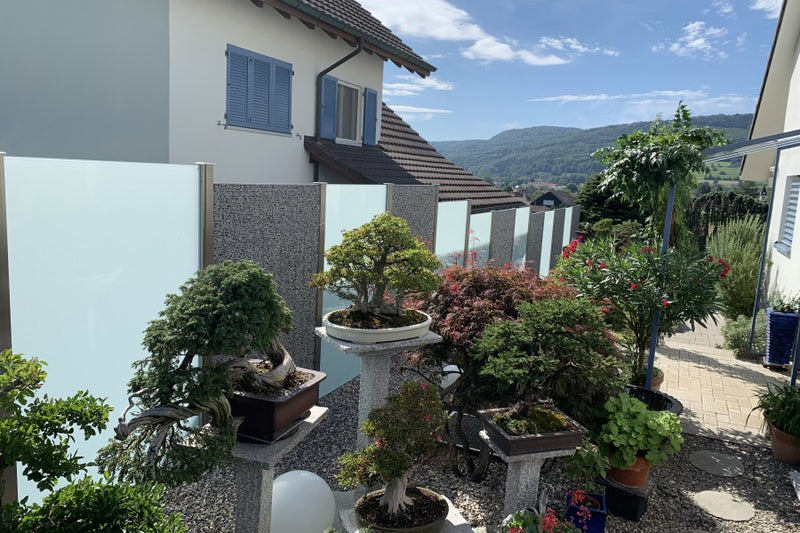 Sicht- und Windschutz aus Steinkörben und VSG-Milchglas – Wallbach AG