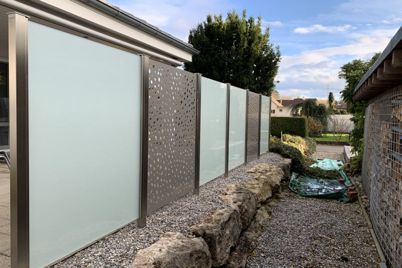 Sicht- und Windschutz aus VSG-Milchglas und Aluminiumblech mit gelasertem Sujet – Möhlin AG