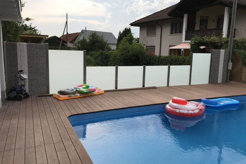 Sicht- und Windschutz aus Steinkörben und VSG-Milchglas – Leibstadt AG