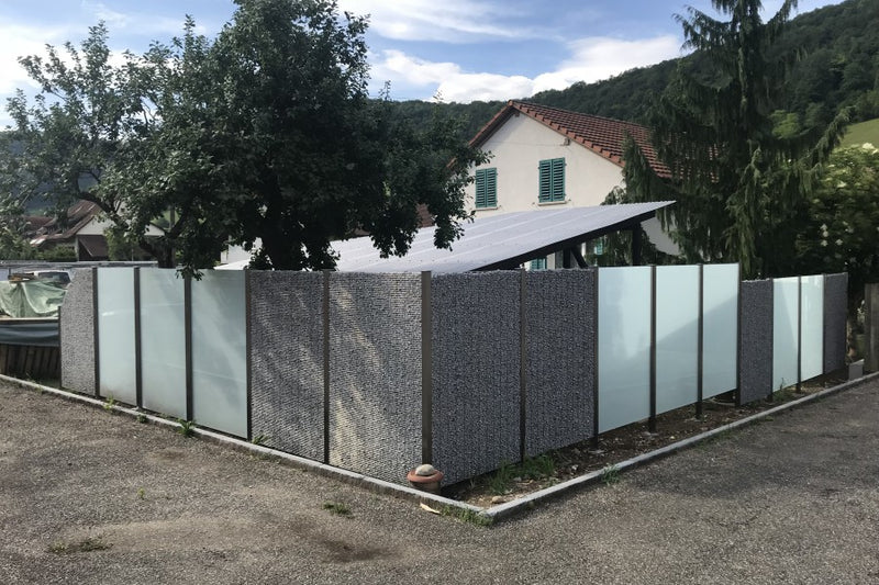 Sicht- und Windschutz aus Steinkörben und VSG-Milchglas – Hornussen AG