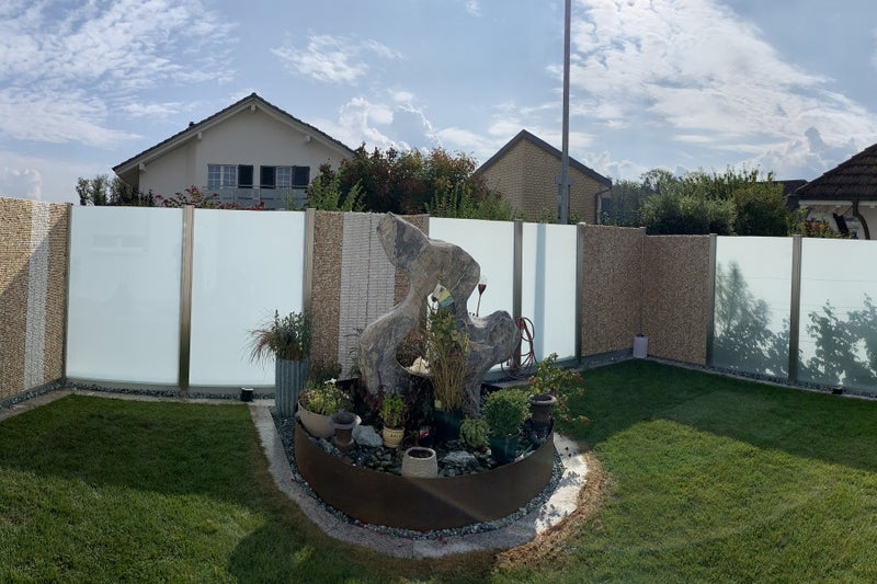 Sicht- und Windschutz aus Steinkörben und VSG-Milchglas, Gartentüre mit gelasertem Familiennamen – Sisseln AG