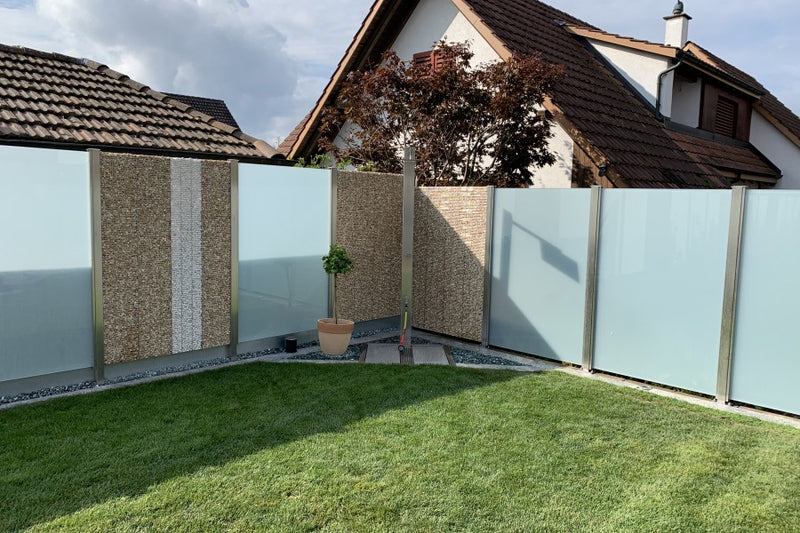 Sicht- und Windschutz aus Steinkörben und VSG-Milchglas, inklusive Gartendusche – Sisseln AG