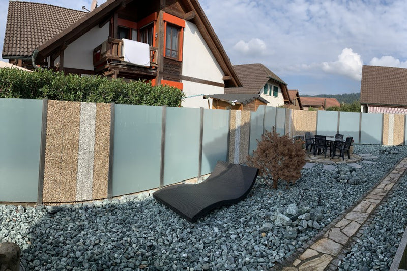 Sicht- und Windschutz aus Steinkörben und VSG-Milchglas – Sisseln AG