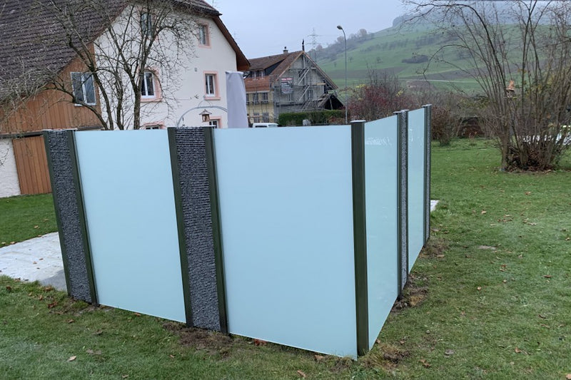 Sicht-, Wind- und Schallschutz aus Steinkörben und VSG-Milchglas – Oberhofen AG