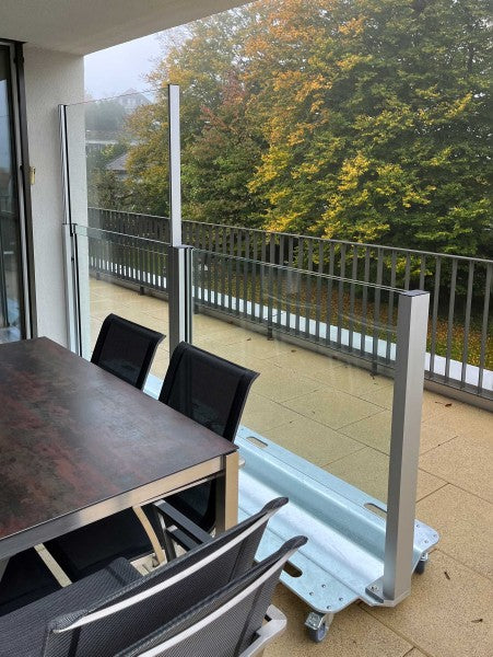 SlideGlass® Windschutz auf der Terrasse, davor das bestehende Stabgeländer
