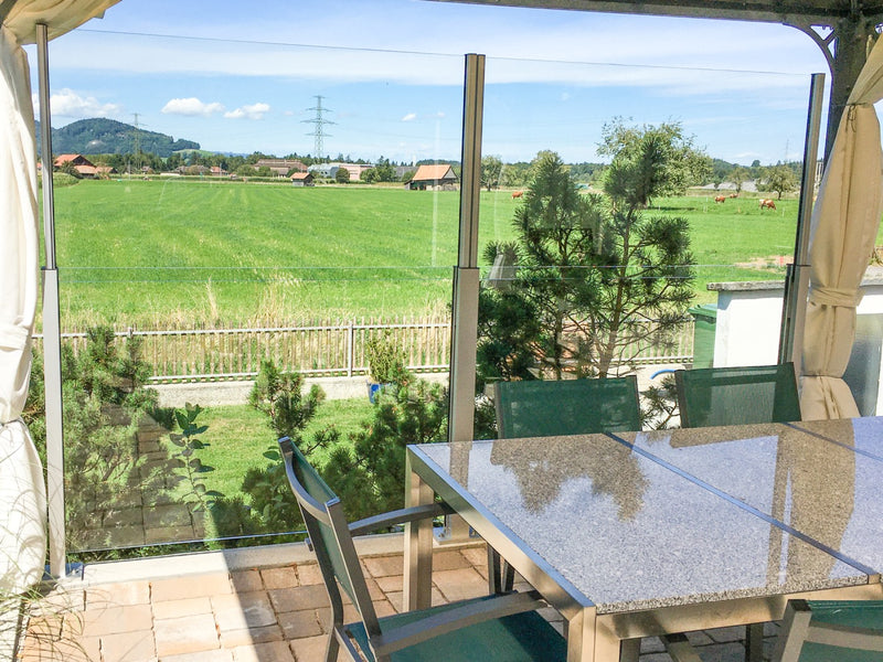 SlideGlass® Windschutz rund um einen Sitzplatz im Grünen