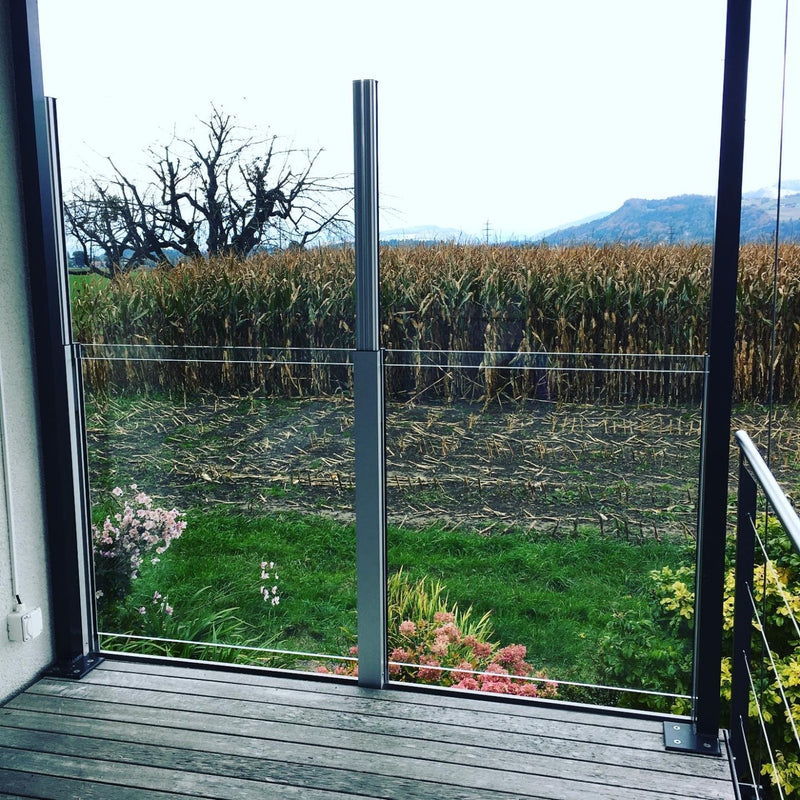SlideGlass® Windschutz mit Klarglas am Gartensitzplatz vor dem Maisfeld