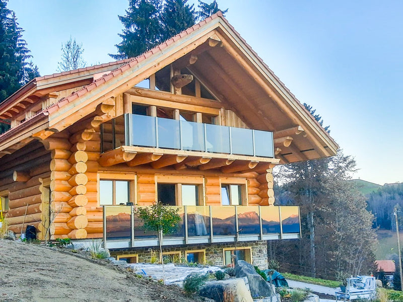 SlideGlass® Balkongeländer mit Klarglas an einem Holzhaus