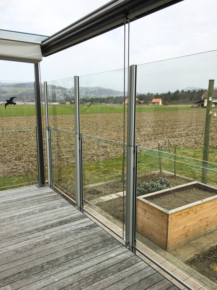 SlideGlass® Windschutz auf dem Holzdeck mit Hochbeeten
