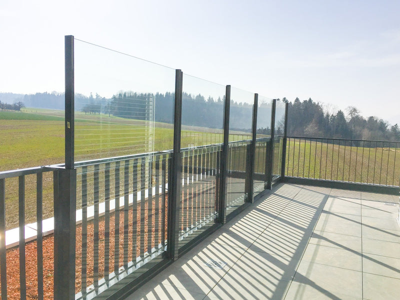 SlideGlass® Windschutz in Anthrazit auf einem langen Balkon