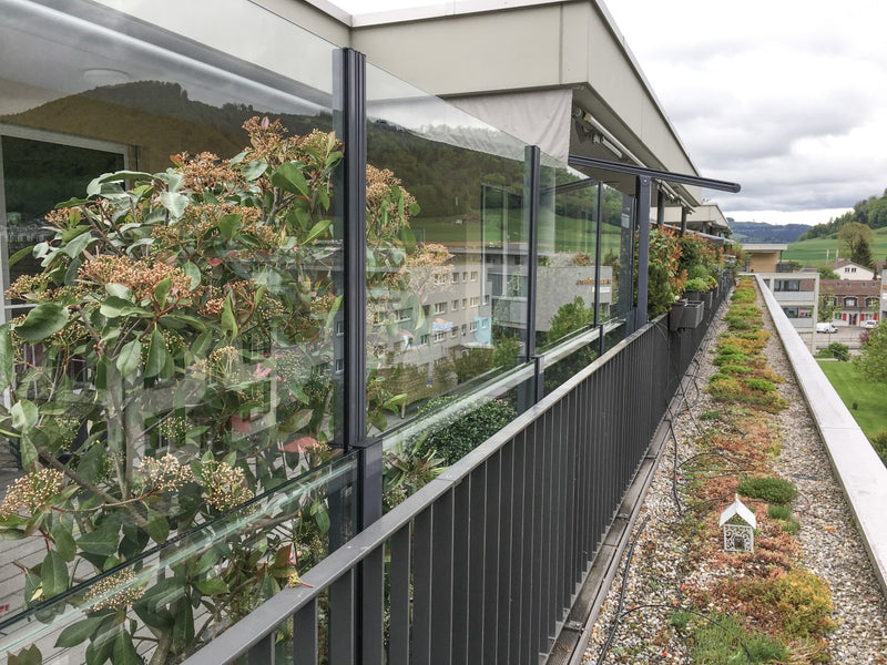 SlideGlass® Windschutzgeländer entlang einer begrünten Dachterrasse