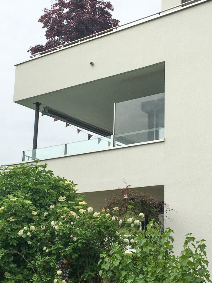 SlideGlass® Balkongeländer an der Ecke eines modernen Hauses