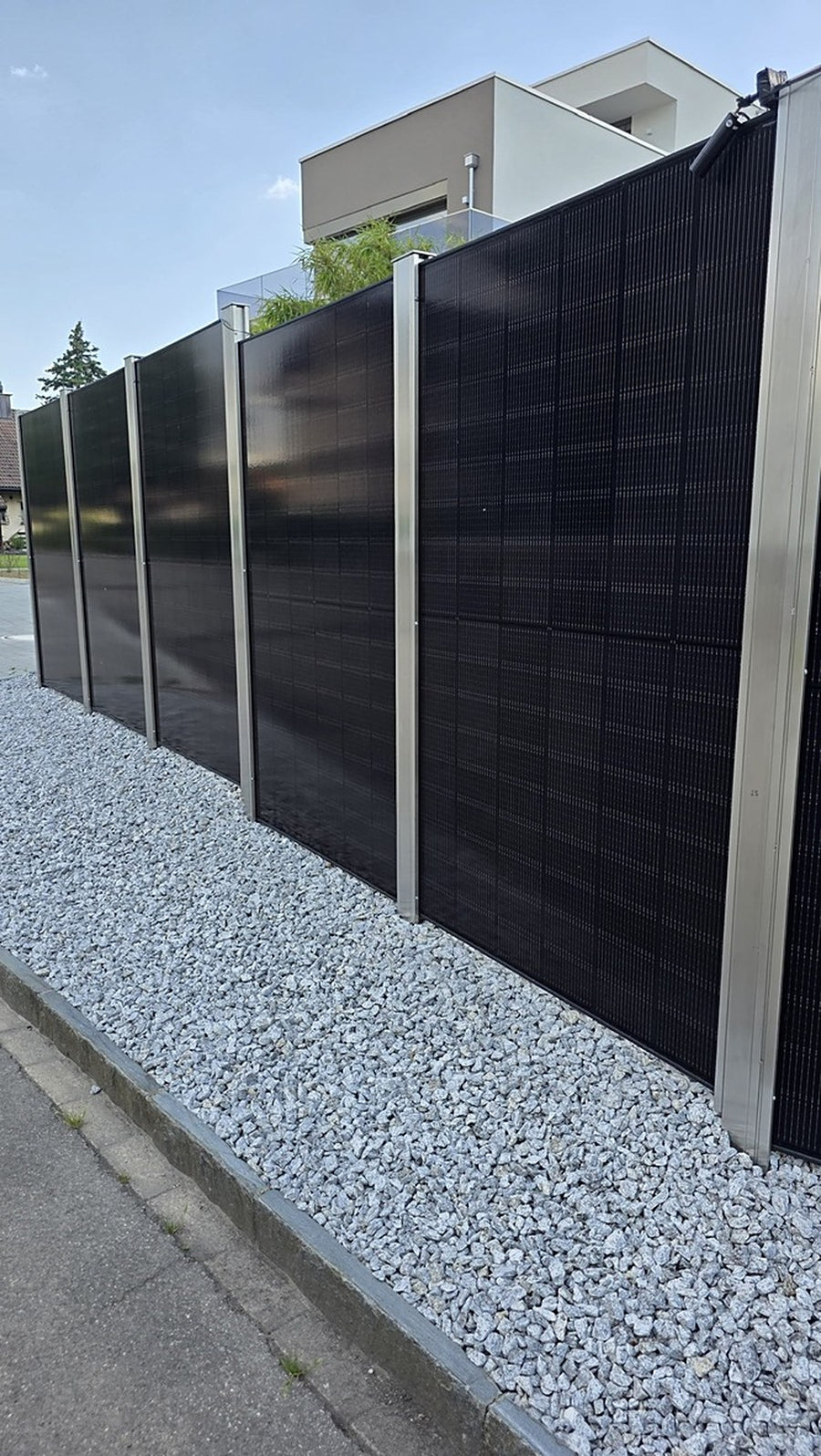 Referenz Mellingen AG: Solar-Sichtschutz mit Edelstahlpfosten auf dem Kiesbett