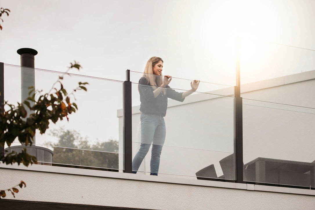 Frau am SlideGlass® Glasgeländer mit freier Aussicht