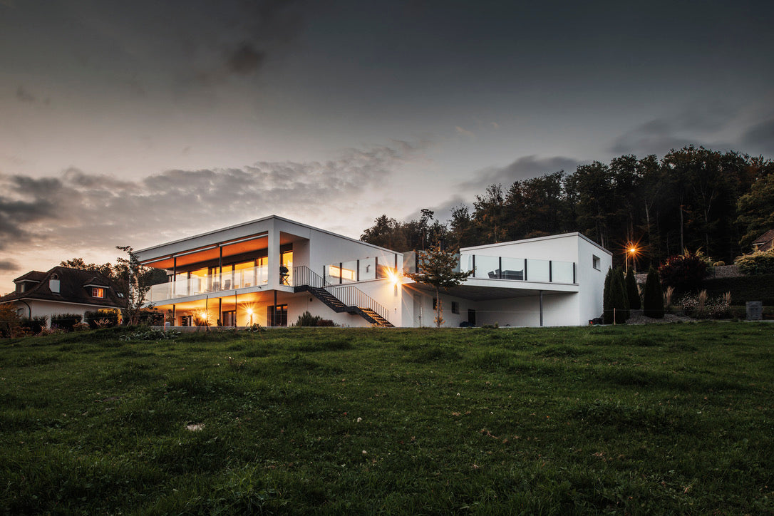 Modernes Haus am Abend mit SlideGlass® Geländern auf Terrasse und Balkon
